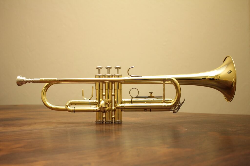 Brass trumpet sitting on wood panel
 table